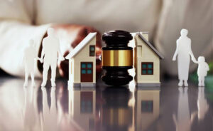Divorce home sale with a judge's gavel between two model houses